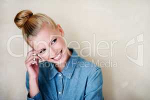 Smiling shyly. A beautiful young woman in casualwear - studio shot.