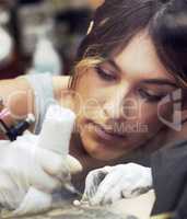 The final product is going to look ink-redible. Shot of a beautiful young tattoo artist at work.