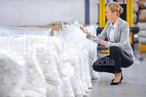 Inspecting the quality of their stock. Shot of a female factory manager doing an inspection of raw materials.