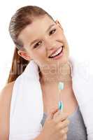 Sparkly white teeth and a radiant smile. A pretty teenage girl holding a toothbrush and smiling.