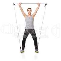 Working hard for the perfect body. A young man working his upper body with a resistance band.