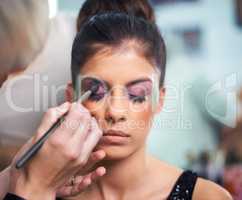 Cosmetic creations. A young woman having makeup applied.