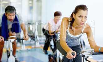 Woman practicing on speed bike at gym. Beautiful woman working out on a stationary bike at the gym.