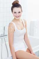 She knows some secrets to beautiful skin. A beautiful young teenage girl sitting on the edge of the bath tub.