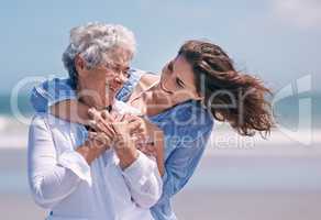 Taking time out to show some tenderness. Shot of a beautiful young woman and her senior mother on the beach.