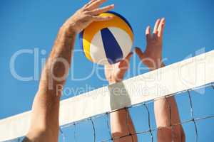 Its anyones point now. Shot of a beach volleyball game on a sunny day.