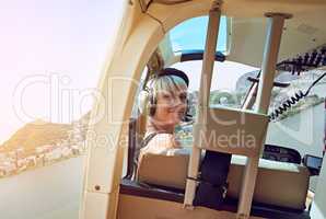 Getting a birds eye view of Rio. Shot of a young woman in the passenger seat of a helicopter flying over Rio.