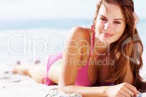 Smiling young girl relaxing on the sea shore. Smiling young womanl in bikini relaxing on the sea shore - Outdoor.