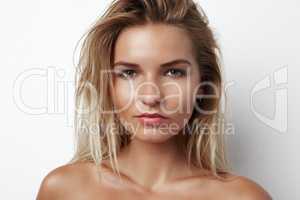 Shes got a raw sensuality. Cropped head and shoulders portrait of a sensual young blonde woman.
