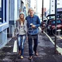 They decided to hit town today. Portrait of a father and daughter walking together in the city with their shopping and takeaway coffee.
