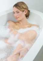 Pure bliss. A beautiful young woman closing her eyes and enjoying a luxurious bath.