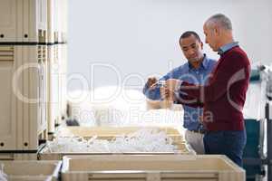 Stock control is vitally important. Shot of two factory managers doing an inspection of raw materials.