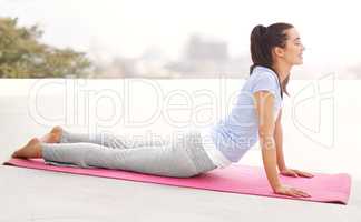 Poise and control. Full length shot of a young woman doing yoga outdoors.