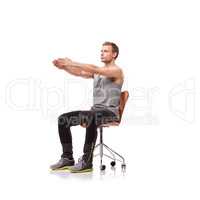 Keeping his limbs long and lean. A handsome young man wearing gym clothes and stretching while seated in an office chair against a white background.