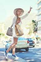 Time to go home her closet awaits. Full length shot of an attractive young woman hailing a cab while holding shopping bags in the city during the day.