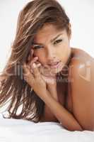Seductive siren. Closeup of a gorgeous young ethnic woman lying topless - portrait.