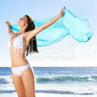 On a summer breeze.... A beautiful young woman holding a sarong thats blowing in the wind.