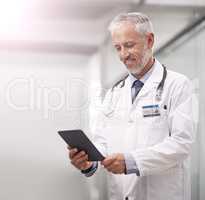 Medical records at the touch of a button. Shot of a mature doctor using a digital tablet in a hospital.