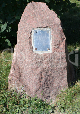 metal plate on granite stone in park at dry sunny summer day