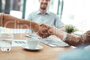 Its a new merger. Shot of two businesspeople shaking hands in an office.