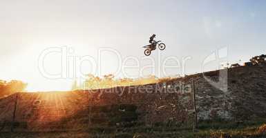 Theres not a competitor in sight. Shot of a motocross rider going over a jump during a race.