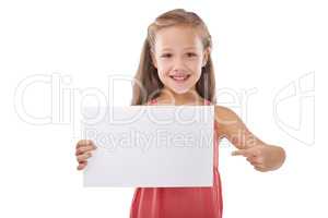 All kids will love this. Cropped shot of a cute young girl pointing at a blank card reserved for copyspace.