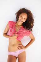 Loving life and feeling great. Curvy young woman in her underwear revealing her midriff and giving a big smile.