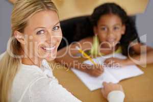 Shes a dedicated educator. Portrait of a pretty teacher helping her student with homework.