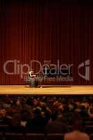 Playing for the crowd. Shot of a young woman playing the piano during a musical concert.