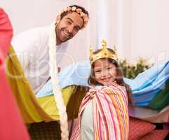 Having so much fun. A cute little girl dressed up as a princess while playing at home with her dad.