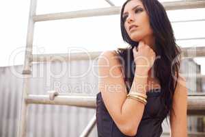 Chic and stylish. A beautiful young woman posing in a chic black dress in an urban setting.