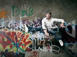 When the beat breaks free. Shot of a teenager breakdancer jumping against a spray painted wall.