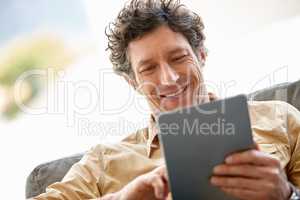 Browsing the web has never been faster. Shot of a mature man using a digital tablet on the sofa at home.