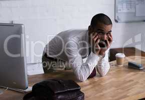 Portrait of a tired businessman leaning on his office desk. Real life businesspeople shot on location. Since these locations are the real thing, and not shot in an office studio, high ISO levels are sometimes needed to catch the moment. The ISO range is b