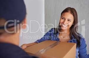 Always find a trustworthy moving company. A beautiful young woman smiling at the camera as she takes a box from a mover.