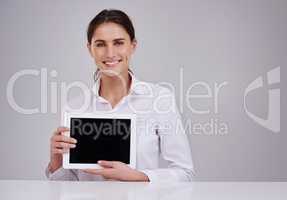 Your online presence is important. Studio portrait of an attractive young woman holding a blank digital tablet.