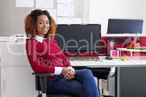 Success- its up to you. Portrait of a young woman sitting at her workstation in an office.