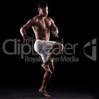 A champion always prepares to win. Studio shot of a young boxer isolated on black.