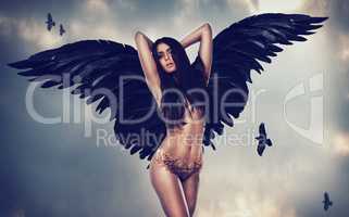 Her beauty is mythical. Shot of a gorgeous woman with feathered wings in a fantasy-like setting.