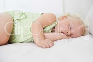 Lost in dreamland. A cute baby girl fast asleep with her thumb in her mouth.