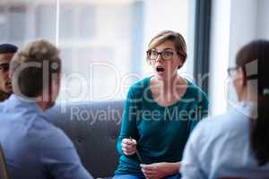 Shes shocked at what shes hearing. Shot of a group of young designers having an informal meeting.