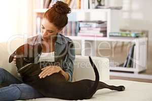 Its not a home without a pet. Shot of a pretty young woman spending time with her dog.