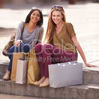 The after affects of a really good shopping spree. Two attractive young woman with their shopping bags after a day of retail therapy.