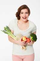 Feeling Great. Happy young woman holding a variety of fruit and veg.