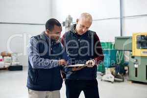 Supervising operations has never been easier. Shot of two factory managers doing a warehouse inspection.