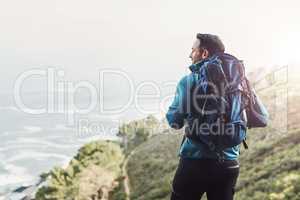 Always dare to explore the beautys nature holds. Rearview shot of a middle aged man hiking in the mountains.