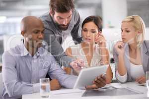 This is where we can save money. Shot of a group of businesspeople discussing the contents of a tablet during a meeting.