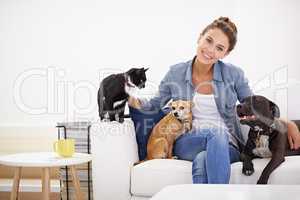 The love rubs off on everybody in her house. Shot of a beautiful young woman relaxing on the couch with her pets.