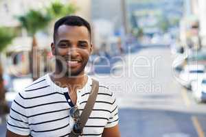 Positivity defines him. A handsome african american businessman out in the city while on his way to work.