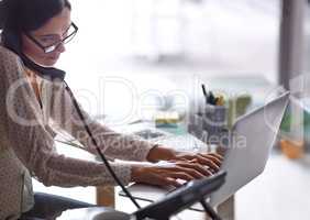 Doing it all at once. Shot of a beautiful young businesswoman working at her desk.